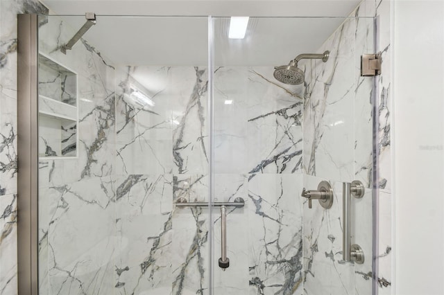 bathroom featuring a marble finish shower