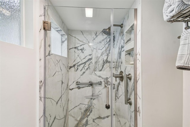 bathroom with a marble finish shower