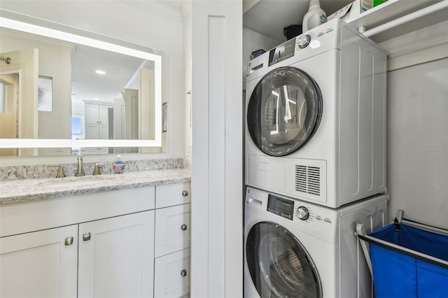 clothes washing area with laundry area, recessed lighting, a sink, and stacked washer / drying machine