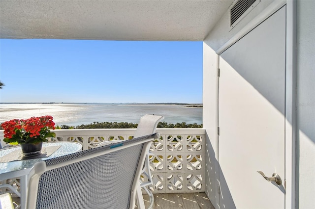 balcony with a water view and visible vents