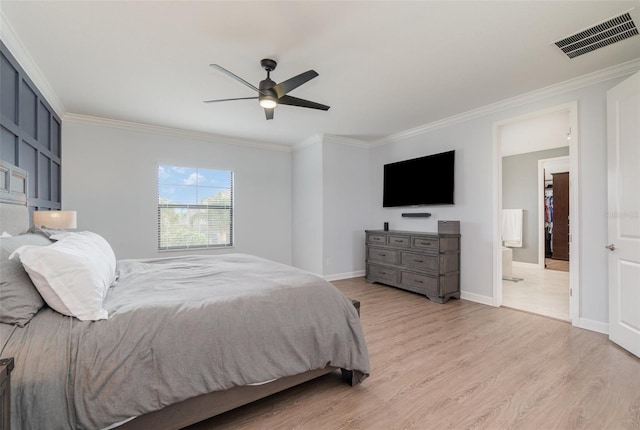 bedroom featuring ceiling fan, light wood-type flooring, crown molding, and ensuite bathroom