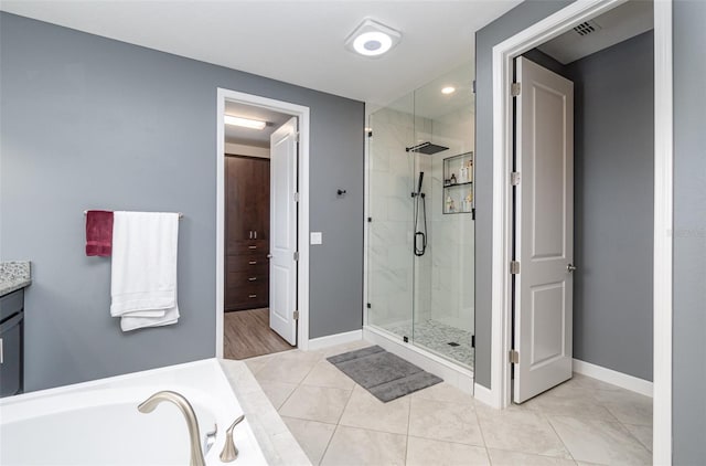 bathroom featuring tile patterned floors, separate shower and tub, and vanity