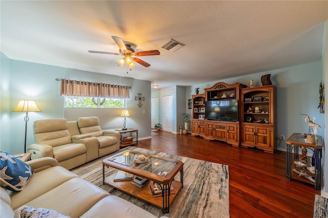 living room with a textured ceiling, dark hardwood / wood-style floors, and ceiling fan