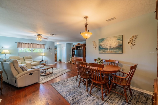 dining space with a textured ceiling, dark hardwood / wood-style floors, and ceiling fan