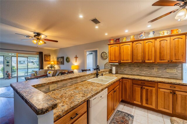 kitchen featuring sink, ceiling fan, white dishwasher, tasteful backsplash, and kitchen peninsula