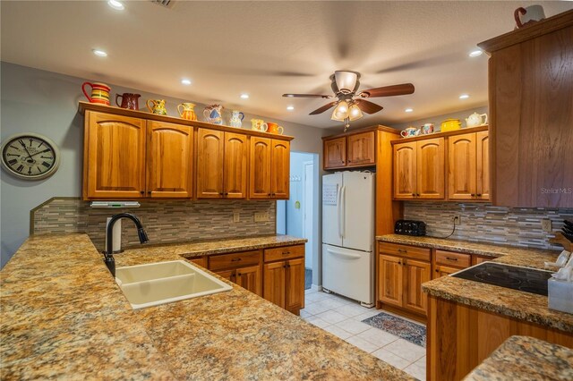 kitchen with white refrigerator, tasteful backsplash, sink, and light tile patterned floors