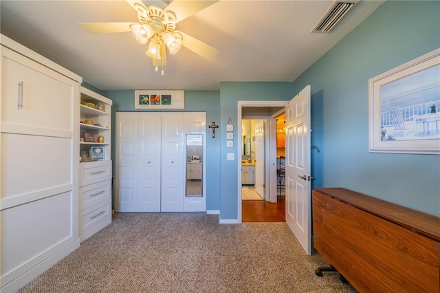 carpeted bedroom with a closet and ceiling fan