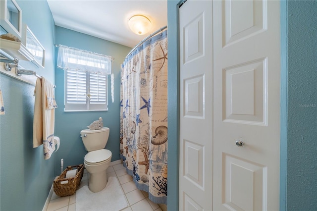 bathroom with tile patterned flooring, a shower with shower curtain, and toilet