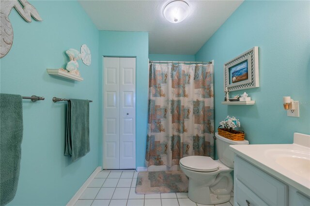 bathroom featuring tile patterned flooring, vanity, a shower with shower curtain, and toilet