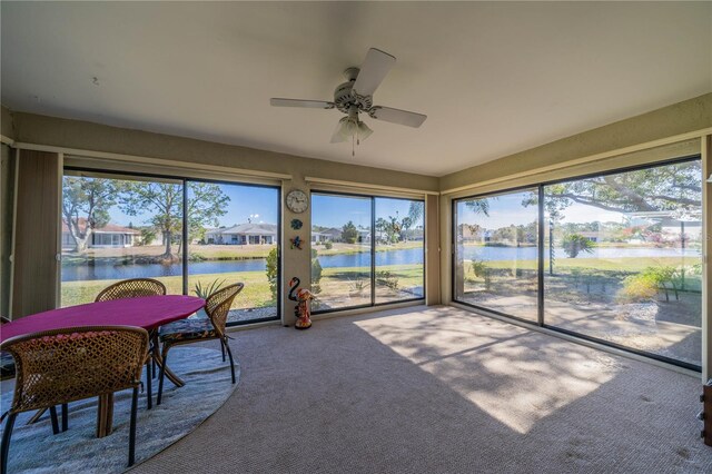 sunroom featuring a water view, a wealth of natural light, and ceiling fan