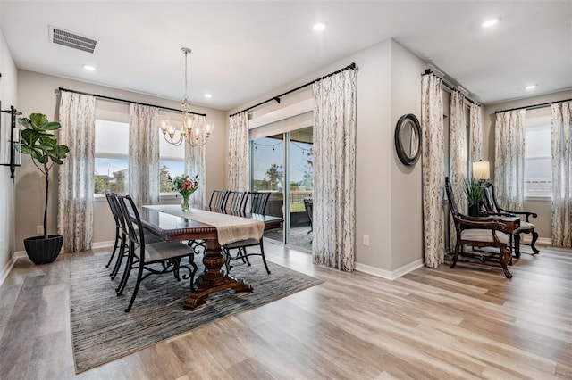 dining space featuring an inviting chandelier and light hardwood / wood-style flooring