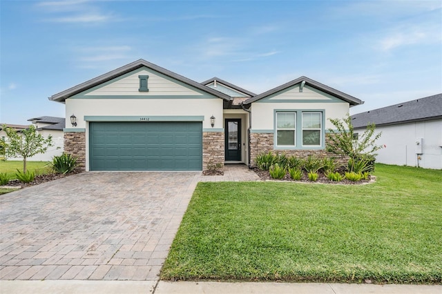 34432 Wynthorne Pl, Wesley Chapel, FL 33545 - view of front facade with stone siding, decorative driveway, a front yard, a garage, and stucco siding