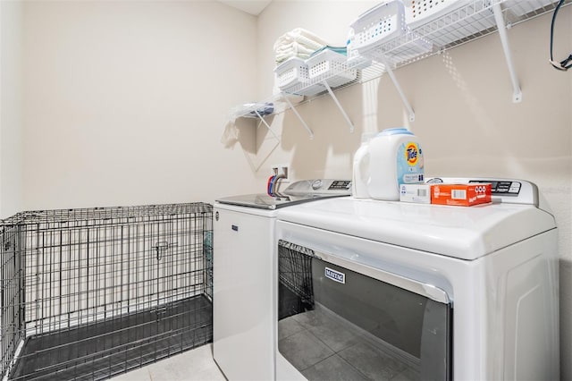 clothes washing area with washing machine and clothes dryer and light tile patterned floors