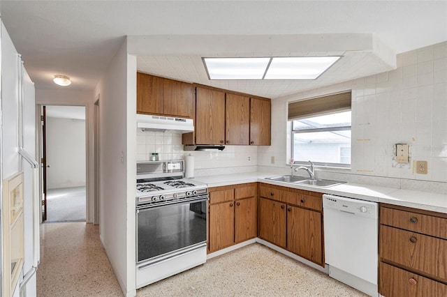 kitchen featuring sink, backsplash, and white appliances