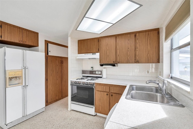 kitchen with sink, a wealth of natural light, white appliances, and decorative backsplash