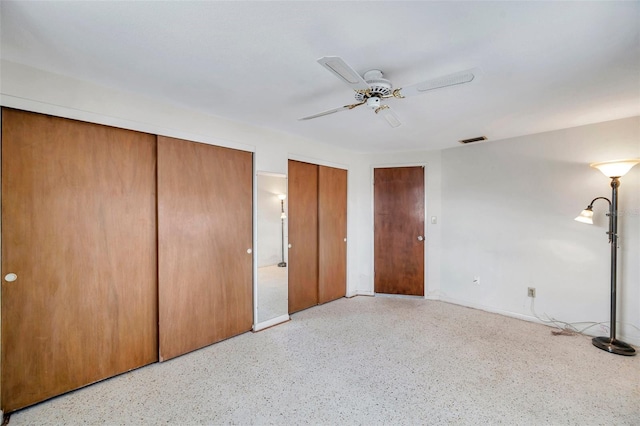 unfurnished bedroom with multiple closets and ceiling fan