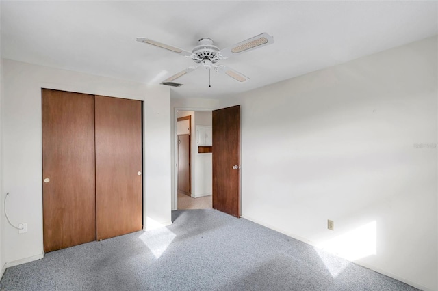 unfurnished bedroom featuring light colored carpet, a closet, and ceiling fan