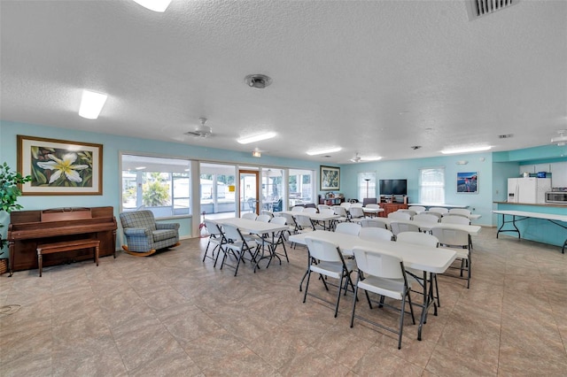 dining space with a textured ceiling and ceiling fan