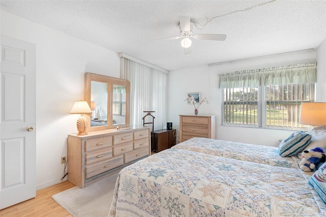 bedroom featuring a textured ceiling, ceiling fan, and light hardwood / wood-style flooring