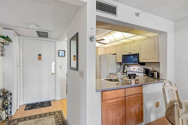 kitchen with white appliances, light hardwood / wood-style flooring, sink, and a drop ceiling