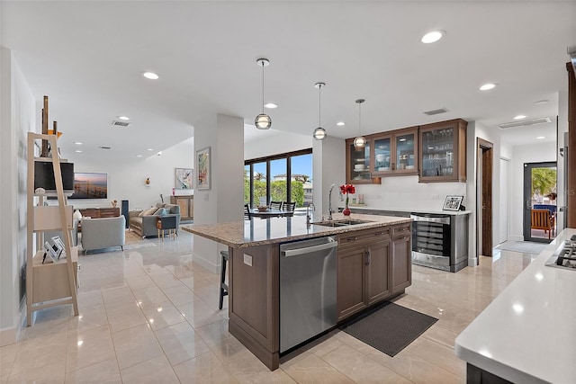 kitchen featuring decorative light fixtures, wine cooler, sink, stainless steel dishwasher, and a breakfast bar area