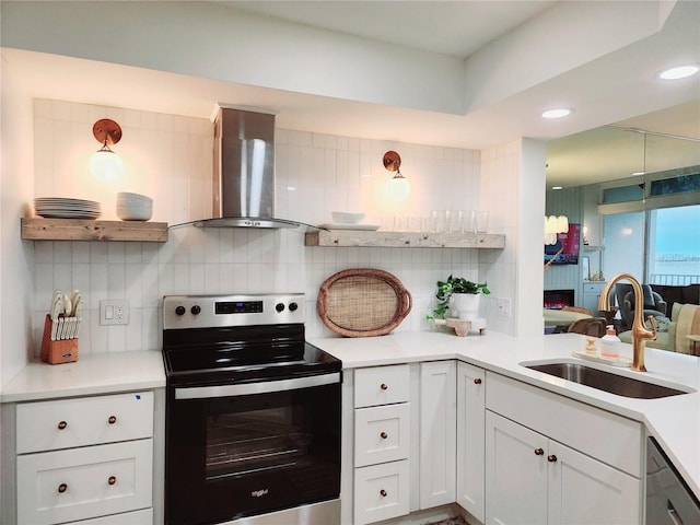 kitchen featuring sink, backsplash, range with electric cooktop, wall chimney range hood, and white cabinets