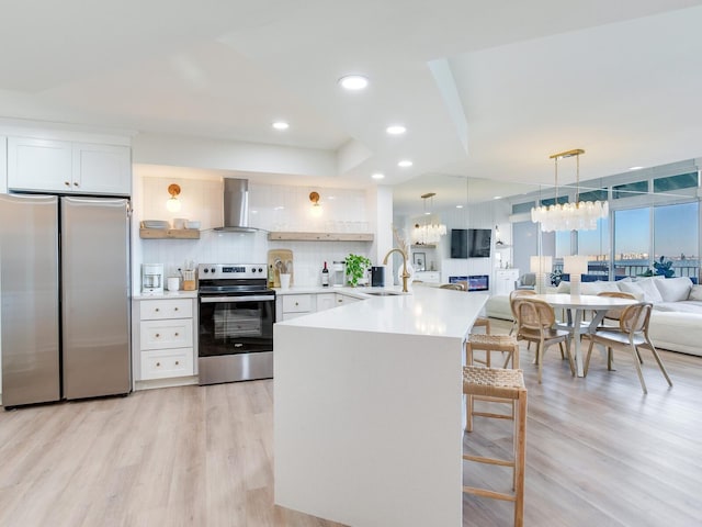 kitchen featuring pendant lighting, white cabinets, appliances with stainless steel finishes, and exhaust hood