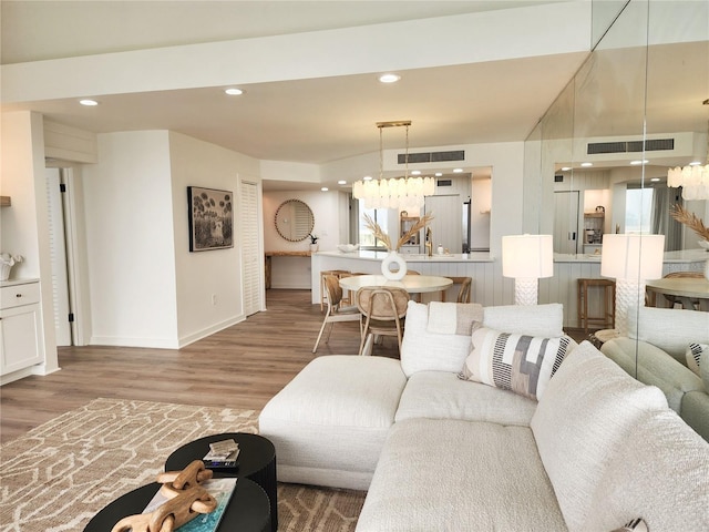 living room with hardwood / wood-style floors and an inviting chandelier