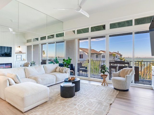 sunroom with a large fireplace and ceiling fan