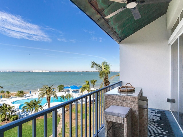 balcony featuring a water view and ceiling fan