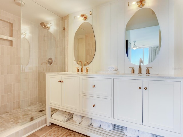 bathroom featuring hardwood / wood-style flooring, vanity, a tile shower, and ceiling fan