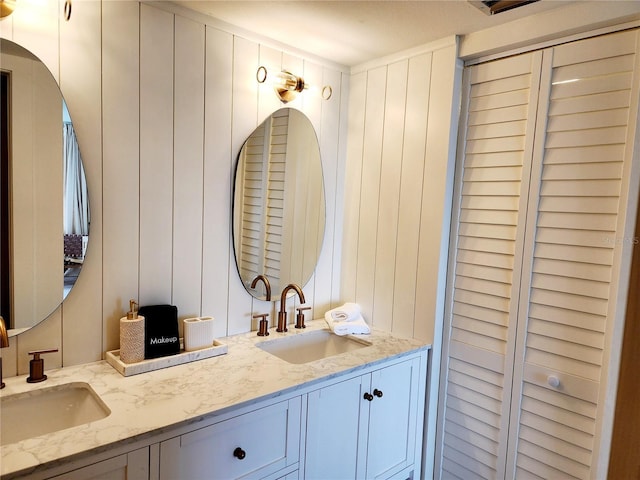 bathroom featuring vanity and wood walls