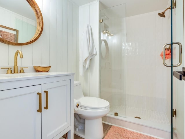 bathroom with vanity, a shower with shower door, and toilet