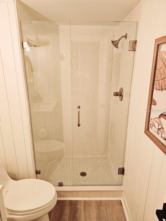 bathroom featuring hardwood / wood-style flooring, toilet, and an enclosed shower