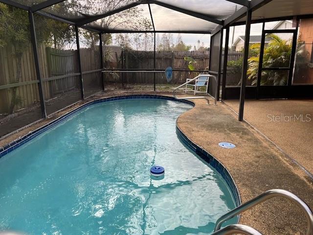 view of swimming pool with a lanai and a patio