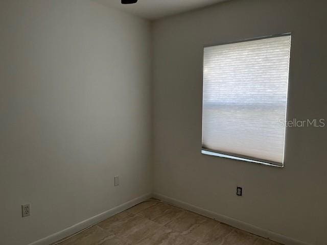 spare room with baseboards