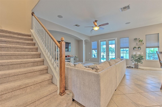 living room with french doors, ceiling fan, and light tile patterned floors