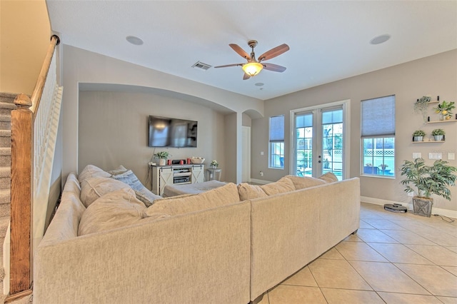 living room featuring light tile patterned flooring, ceiling fan, and french doors