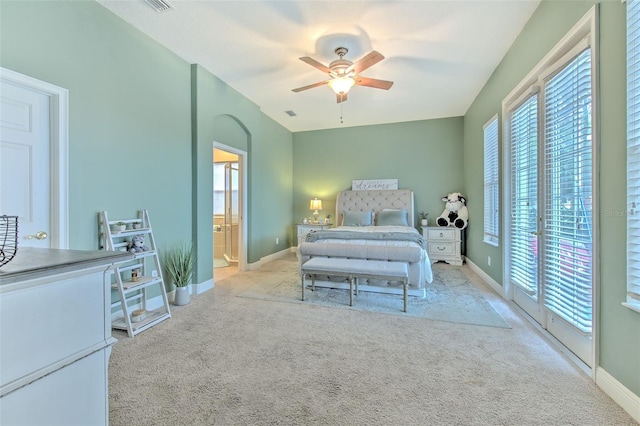 bedroom with connected bathroom, access to outside, light carpet, and ceiling fan