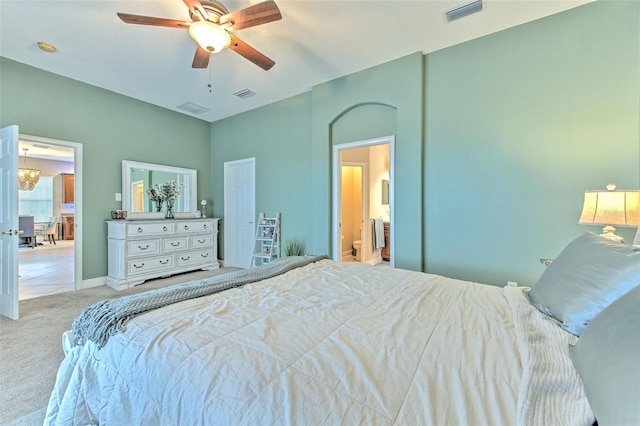 bedroom with ceiling fan, connected bathroom, and light carpet