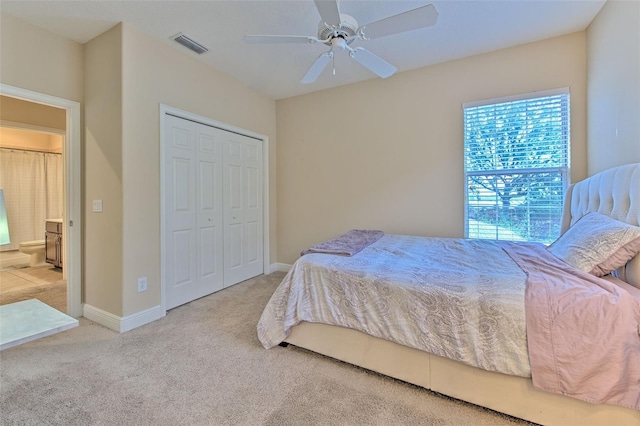 bedroom featuring light colored carpet, a closet, and ceiling fan