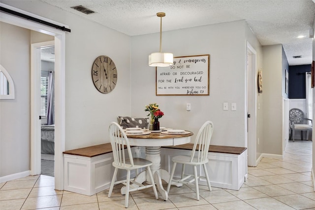 dining area featuring a textured ceiling, light tile patterned floors, and breakfast area