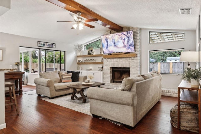 living room with a fireplace, a textured ceiling, ceiling fan, and dark hardwood / wood-style floors