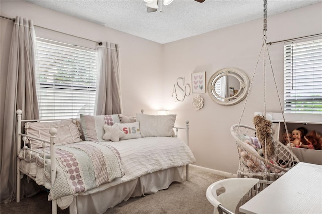 bedroom featuring ceiling fan, carpet floors, and a textured ceiling