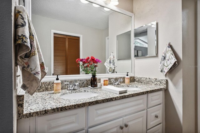 bathroom featuring a textured ceiling and vanity