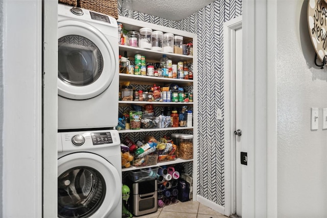 laundry area with stacked washer and dryer and light tile patterned flooring