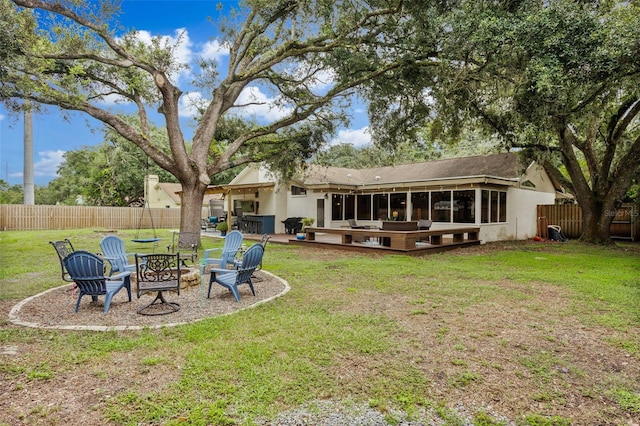 back of property with a fire pit, a yard, and a patio area