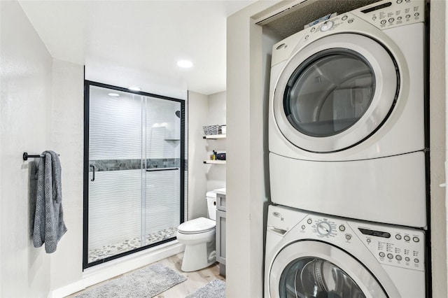 laundry room with light hardwood / wood-style flooring and stacked washer and dryer