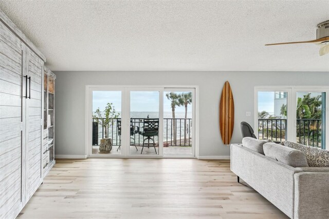 unfurnished living room featuring plenty of natural light, a textured ceiling, and a water view