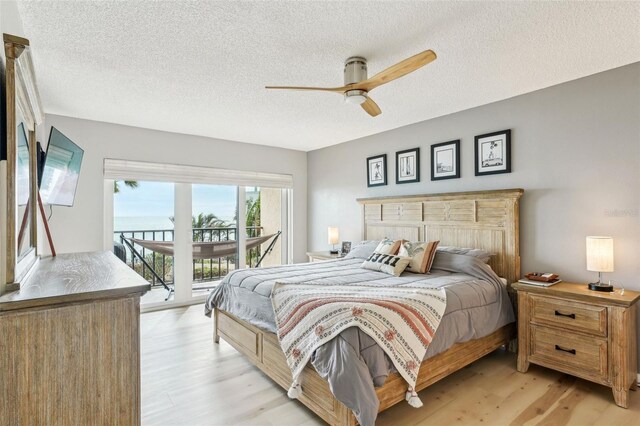 bedroom with ceiling fan, a textured ceiling, access to outside, and light wood-type flooring